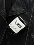 Villain Era candle in a black glass jar resting on a black leather jacket