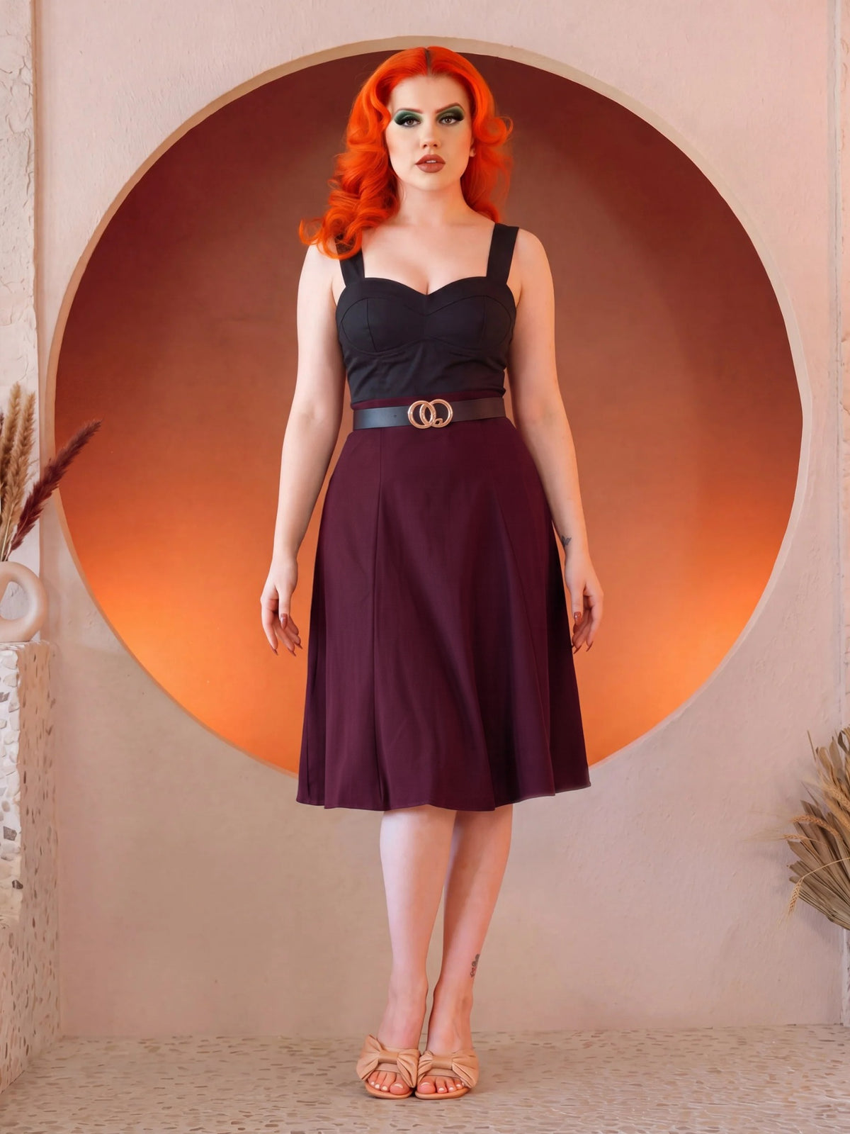 Model in the Viva 40s Tulip Skirt in Burgundy with a black sweetheart top and gold ring belt, full length front view