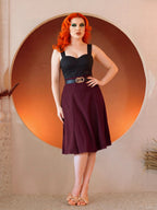Model in the Viva 40s Tulip Skirt in Burgundy, hand on hip, showing the high waist and the flare of the paneled skirt
