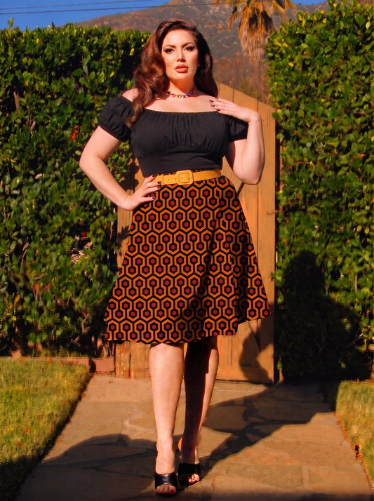 Viva 40s tulip swing skirt in the orange and black Hotel Hexagon print, worn with a black peasant top, mustard belt and black peep toe mules