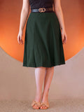 Viva 40s Tulip Skirt in Hunter Green from the waist down, high waist with a gold ring belt, paneled skirt flaring to just below the knee, worn with tan bow sandals