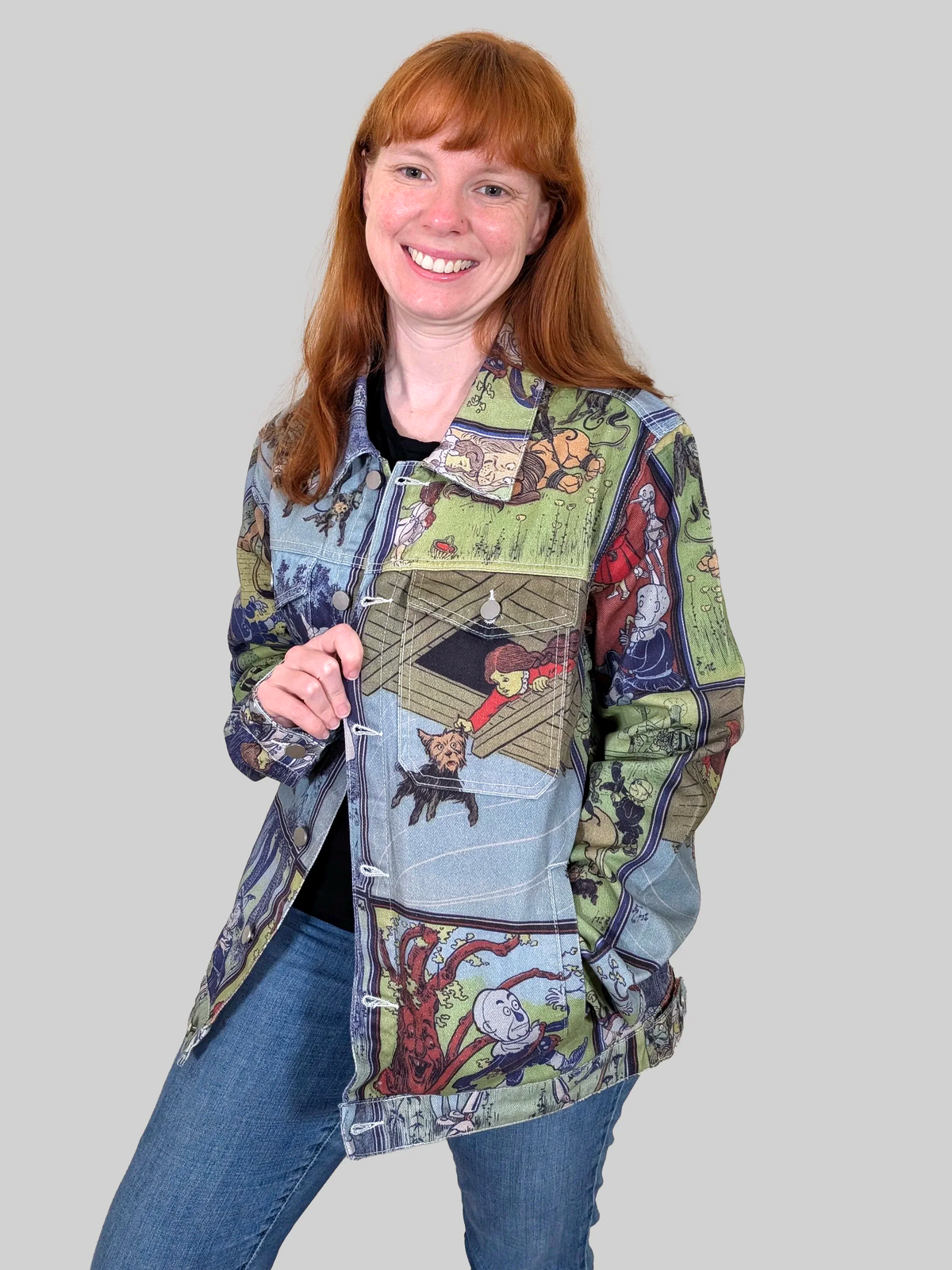 Woman wearing the Wizard of Oz Denim Jacket open over a black top and jeans, front view