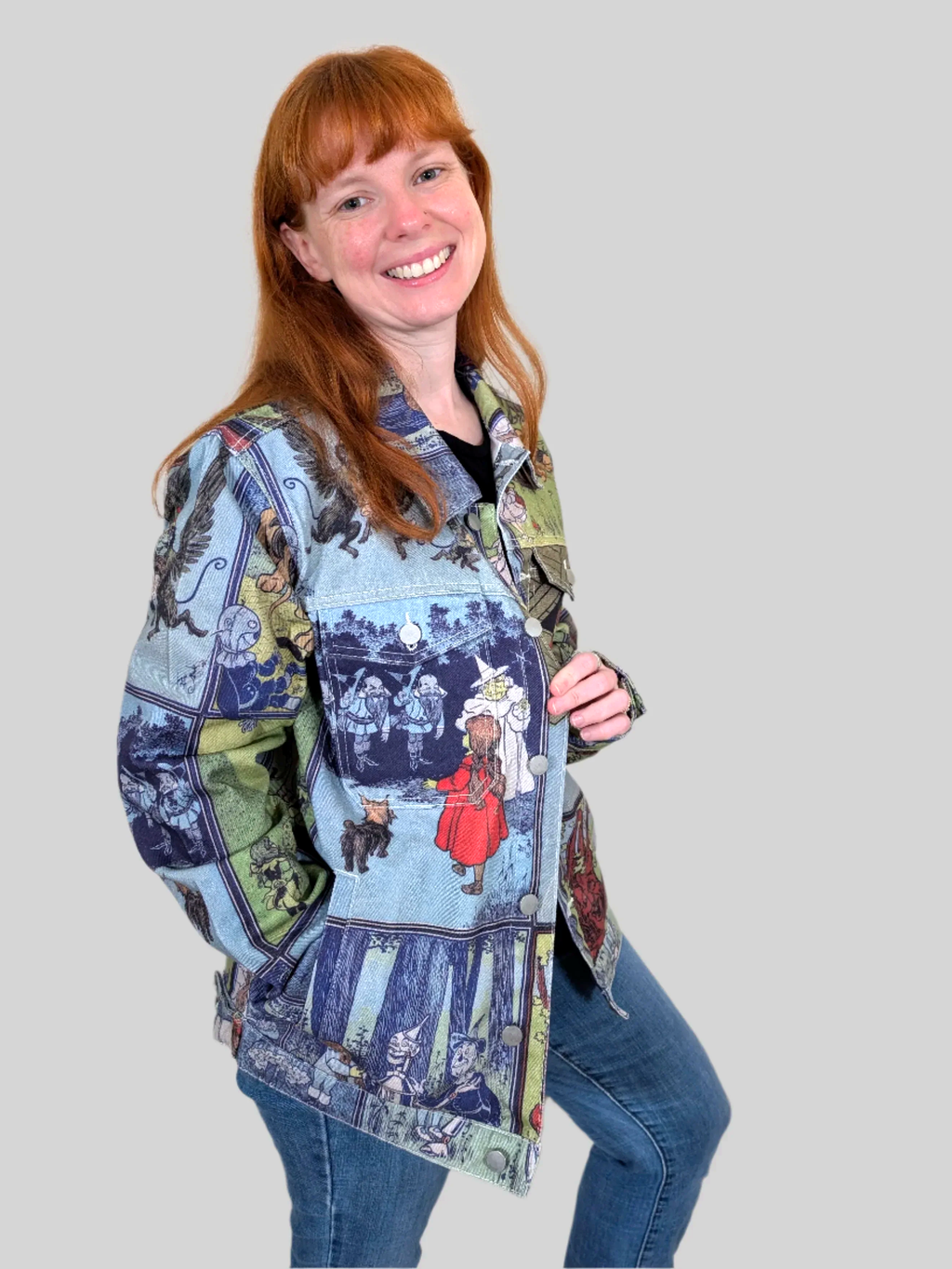 Three-quarter view of the Wizard of Oz Denim Jacket worn open, storybook print on the sleeves