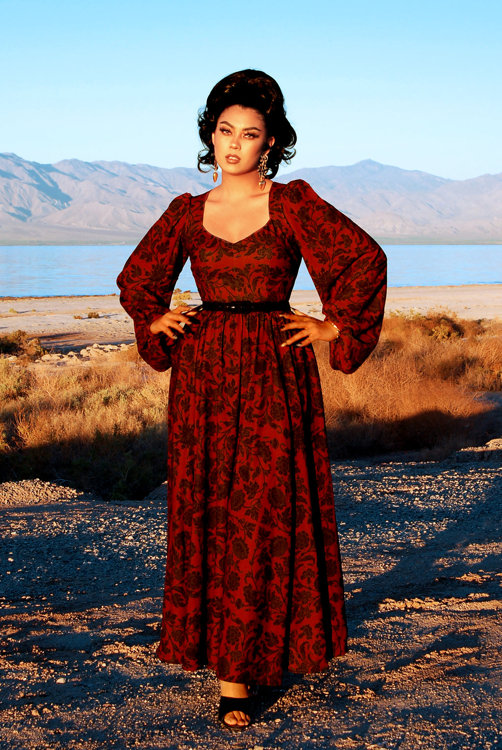 Lucrezia Renaissance Maxi Gown in black on red Capri Floral crepe, with a sweetheart neckline, bishop sleeves, and a full circle skirt with pockets.