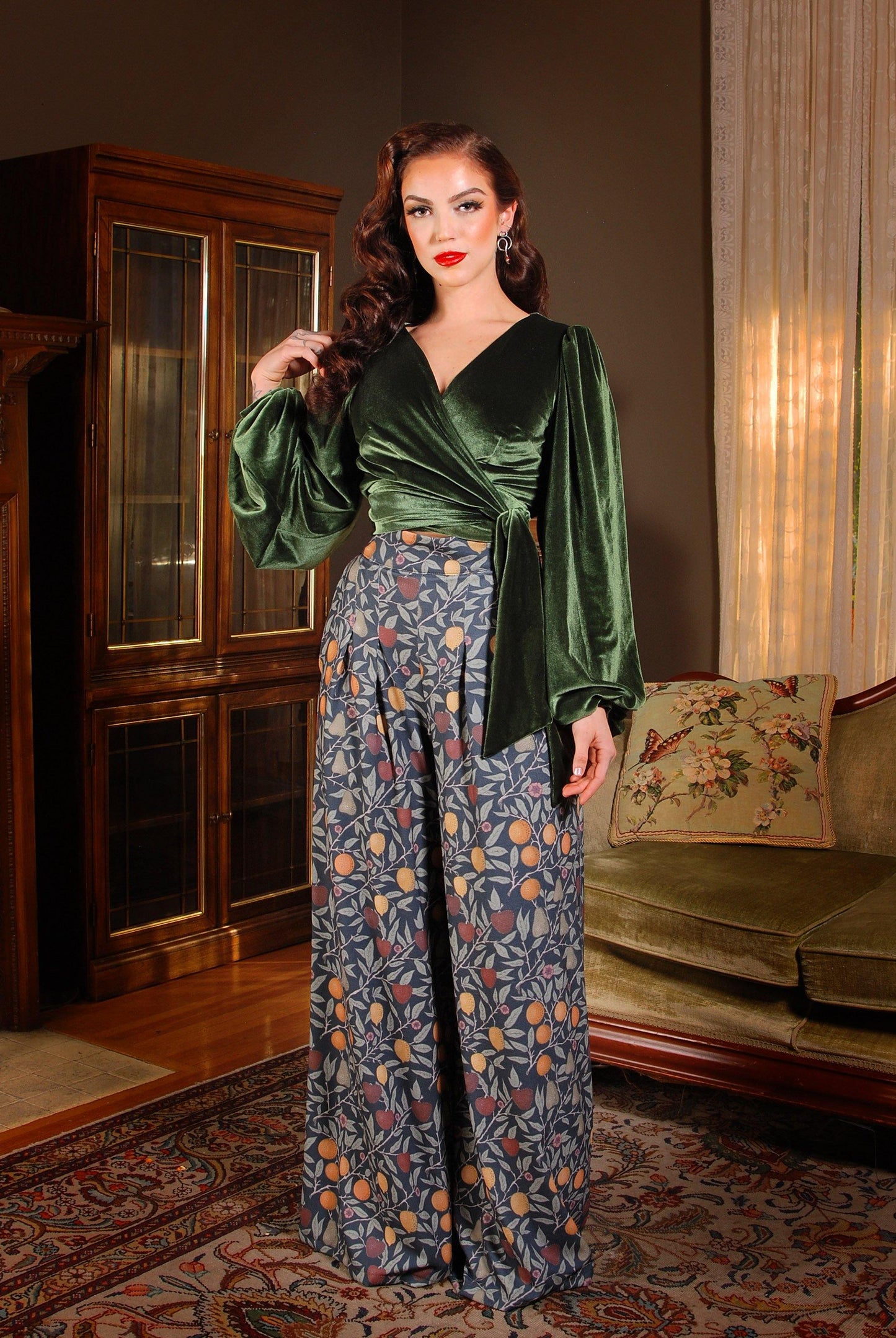 Pinup Girl Clothing models Cora Morgan and Seattle pose in the PUG favorite Dietrich vintage inspired wide leg palazzo pants with pockets made of high quality stretch crepe in the exclusive Laura Byrnes and Hope Morrison Night in Eden Fruit Print.
