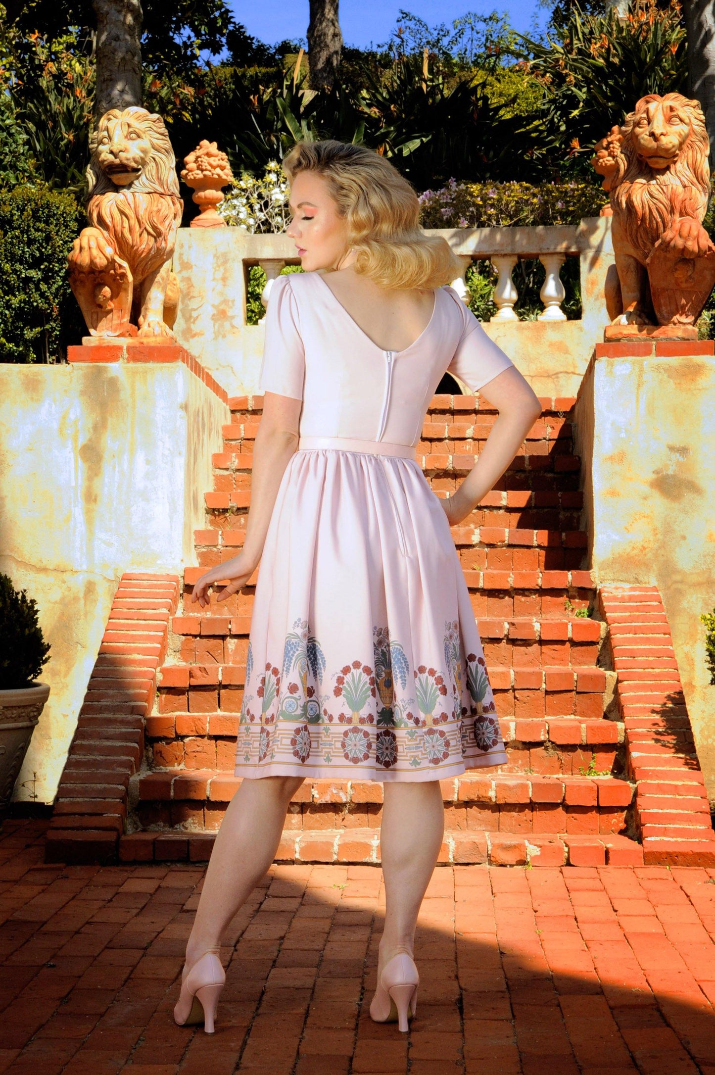 Pictured is Pinup Girl Clothing model Grace Gordon in the Paige dress with short sleeves, sweetheart bust, and full swing skirt made from stretch gabardine, with a full back zip, and pockets.
