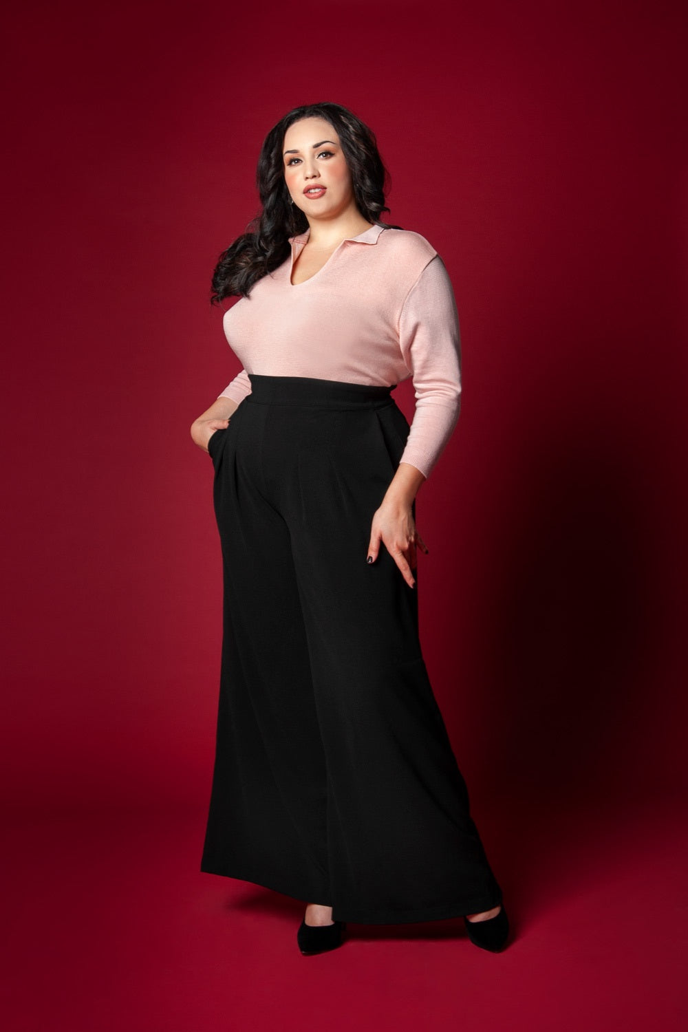 Pinup Girl Clothing model Coco Lamarr poses in PUG brand favorite Dietrich vintage inspired wide leg trouser palazzo pants with pockets made of high quality stretch crepe in black 30" inch inseam